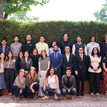 Foto de grupo de egresadas y egresados en un jardín del campus